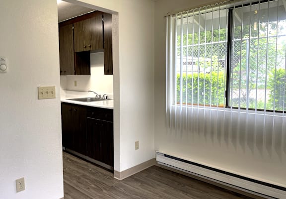A kitchen with white walls and wooden cabinets.