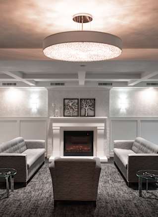 A modern living room with a fireplace and two grey couches.