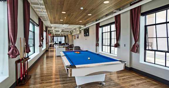 a games room with a pool table in the middle of it