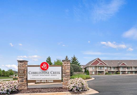 A sign for Cobblestone Creek Luxury Apartment Homes with a phone number on it.