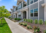 Thumbnail 1 of 8 - a row of townhomes with a sidewalk in front of them