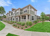 Thumbnail 7 of 8 - an apartment building with green grass and a sidewalk