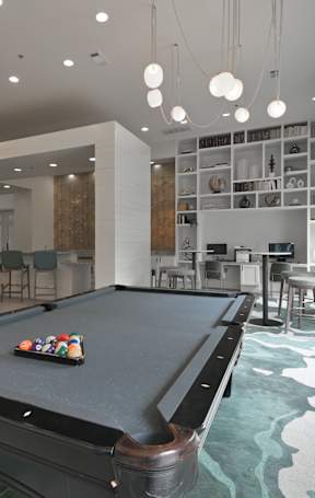 A pool table in a room with a green and white patterned carpet.