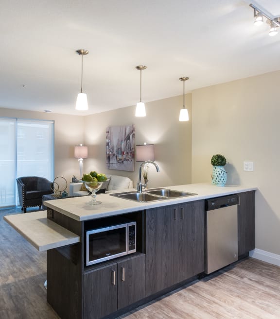 a kitchen with an island and a living room in the background
