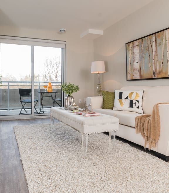 a living room with a sliding glass door that leads to a balcony