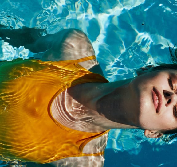 a girl in a yellow shirt swimming in a pool  at The Griffin Royal Oak, Royal Oak, Michigan