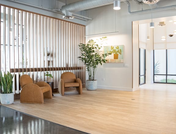 A room with a wooden floor and a large window with vertical blinds.
