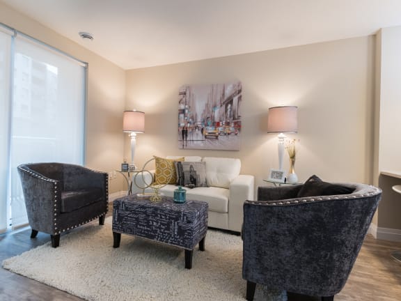 a living room with a white couch and two black chairs