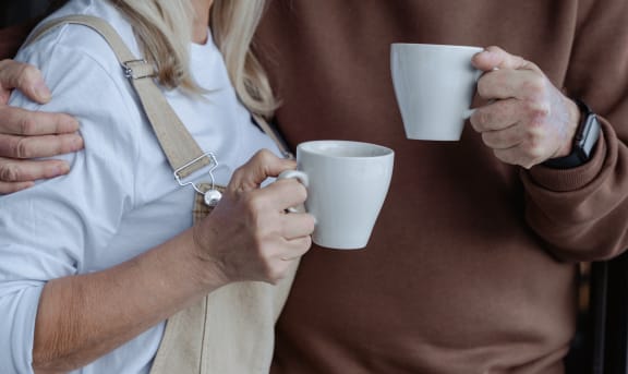 a man and a woman holding coffee mugs