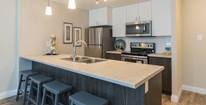 a kitchen with a large island and stainless steel appliances