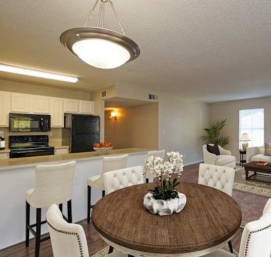 A modern dining room with a wooden table and white chairs.