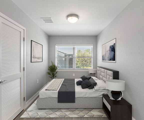 A bedroom with a bed, nightstand, and window.