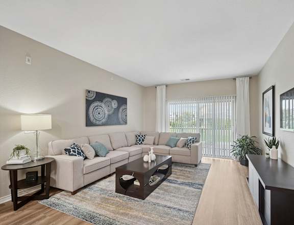 A living room with a couch, a coffee table, and a painting on the wall.