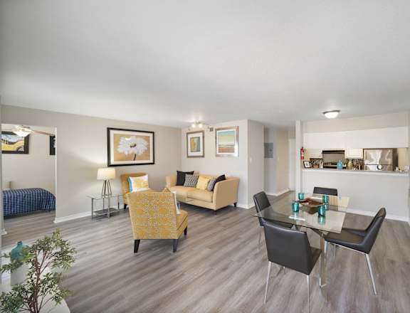 A living room with a yellow chair and a glass table.