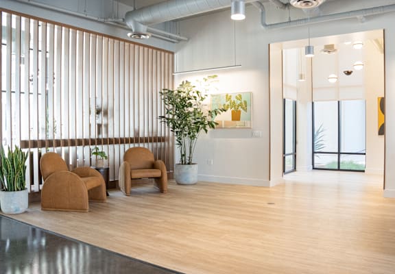 A room with a wooden floor and a large window with vertical blinds.