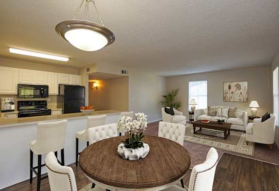 A modern dining room with a wooden table and white chairs.