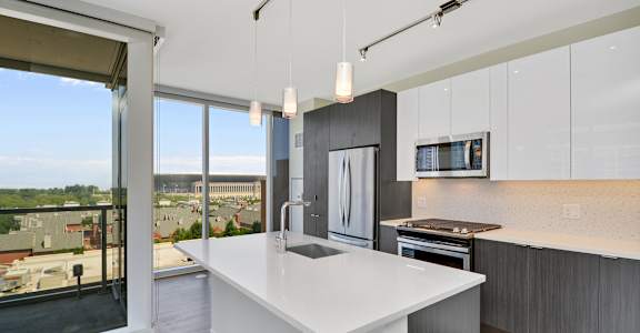an open kitchen with a large white island and a large window