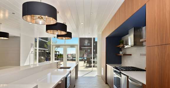 a kitchen with white countertops and stainless steel appliances and a blue accent wall
