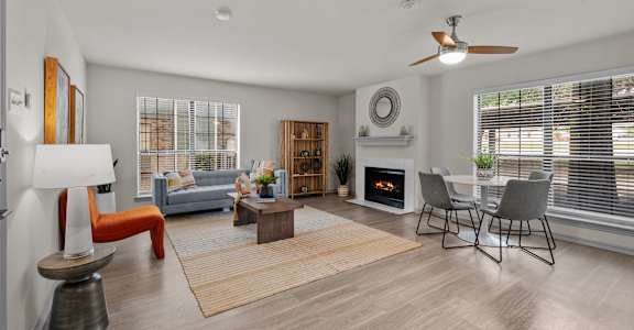 A modern living room with a fireplace and a dining area.