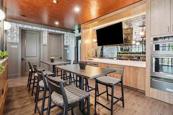 A kitchen with a long table and chairs.