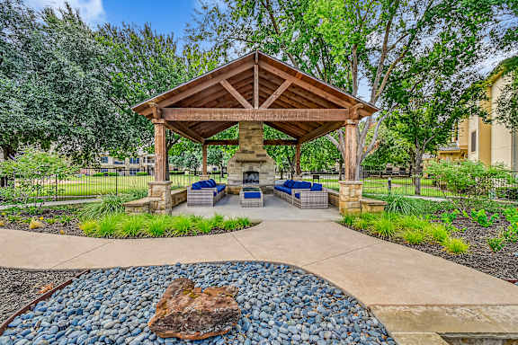 A gazebo is surrounded by a gravel area and a paved walkway. at The Canyons Apartments, Fort Worth, 76116