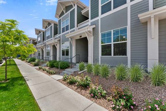 a row of townhomes with a sidewalk in front of them