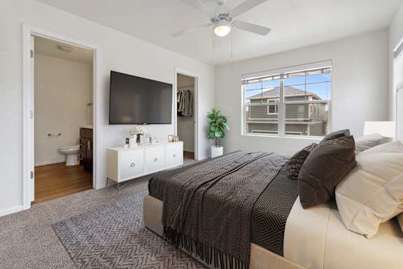 a bedroom with a large bed and a ceiling fan