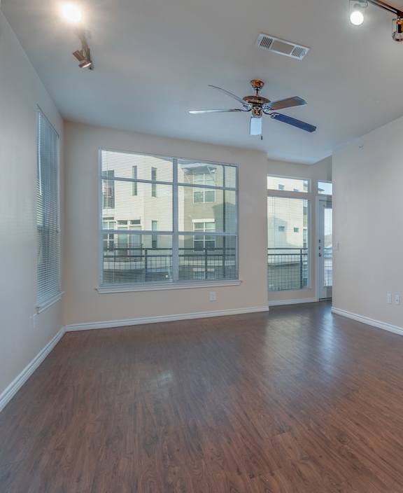 Empty room with a ceiling fan and wooden flooring. at Millennium on Post Apartments, Texas