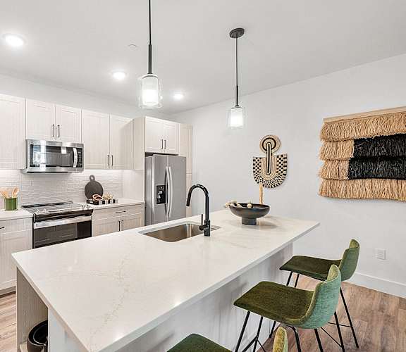 a kitchen with white cabinets and a white counter top and a stainless steel refrigerator