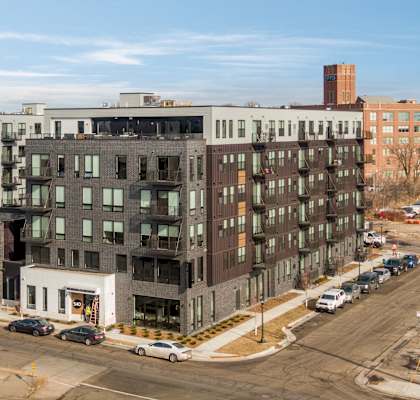 A large multi-story building with a parking lot in front.