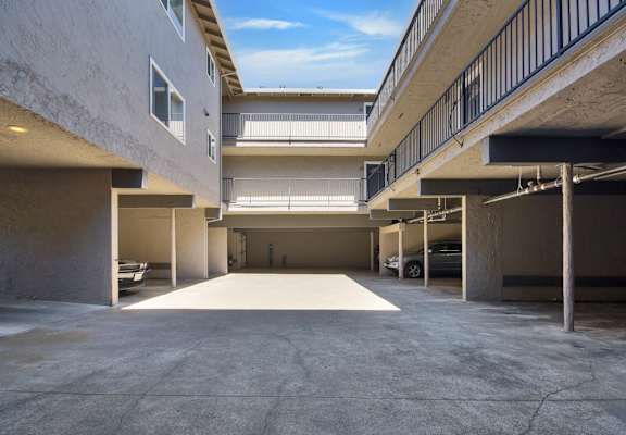 A parking garage with a clear blue sky visible through the windows.