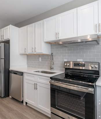 a kitchen with white cabinets and stainless steel appliances