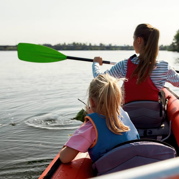 a mother and daughter in a kayak on a lake