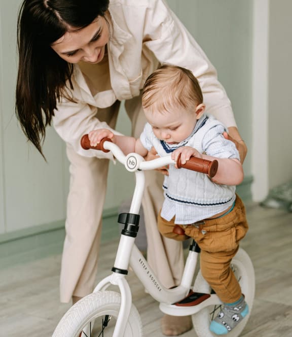 a woman holding a baby on a bike