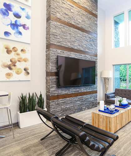 A living room with a blue chair and a fireplace.