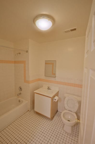 Bathroom with white tiled floor and cabinets