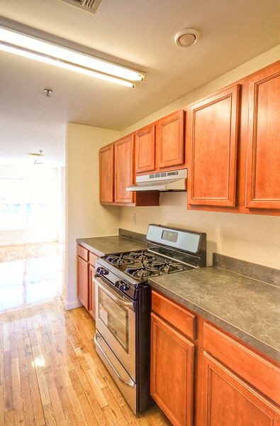 Kitchen with stainless steel appliances, wooden cabinets and hardwood floors