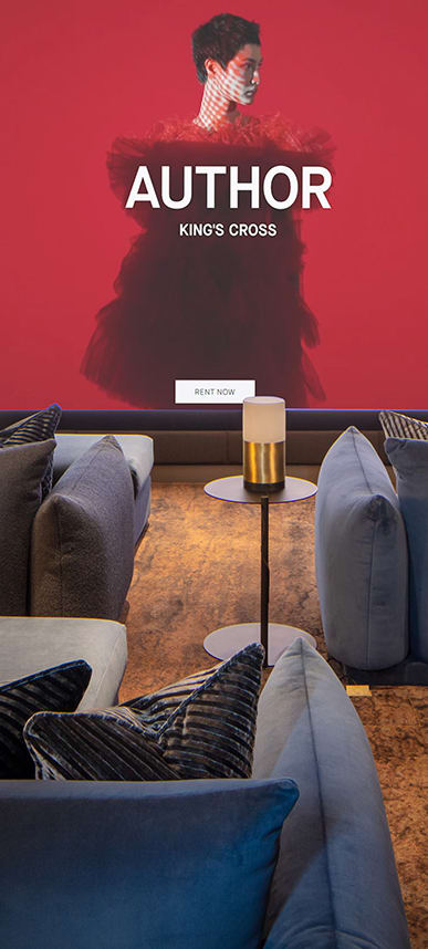 a living room with couches and chairs and a red wall with a movie poster