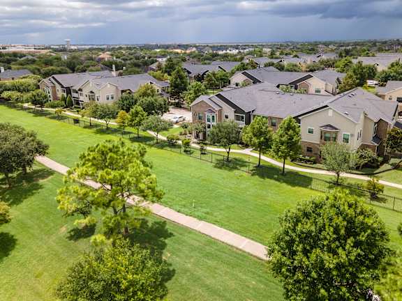 A suburban neighborhood with houses and green lawns at Avenues at Shadow Creek Ranch Apartments, Pearland, 77584