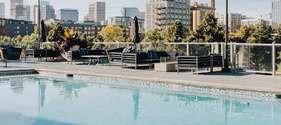 a swimming pool with a city skyline in the background