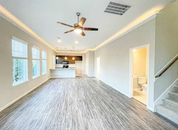 A spacious room with a ceiling fan and lighting fixtures.