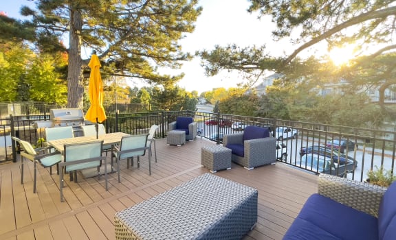 Community lounging deck with blue couch seating and an outdoor table with yellow umbrella