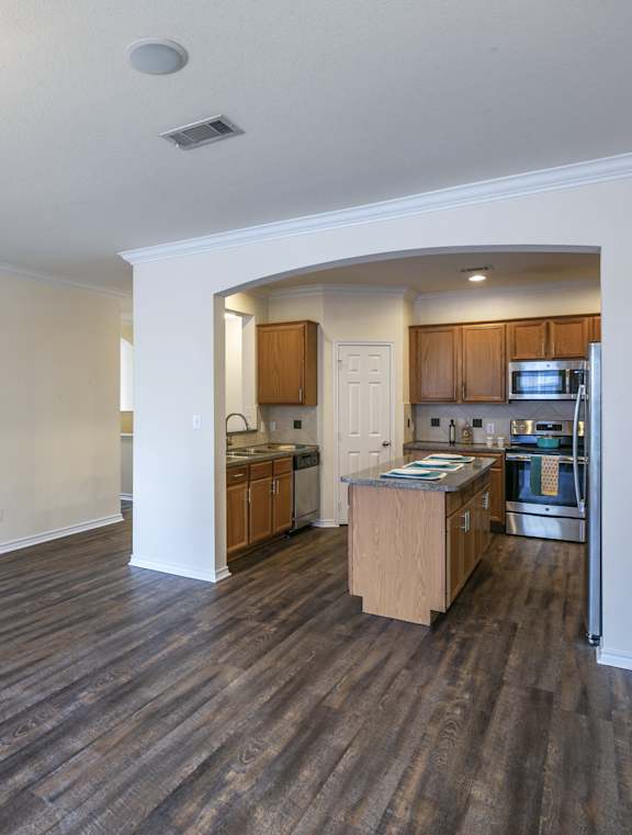 A kitchen with wooden cabinets and a refrigerator.