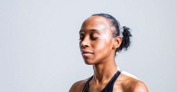a woman meditating on a yoga mat