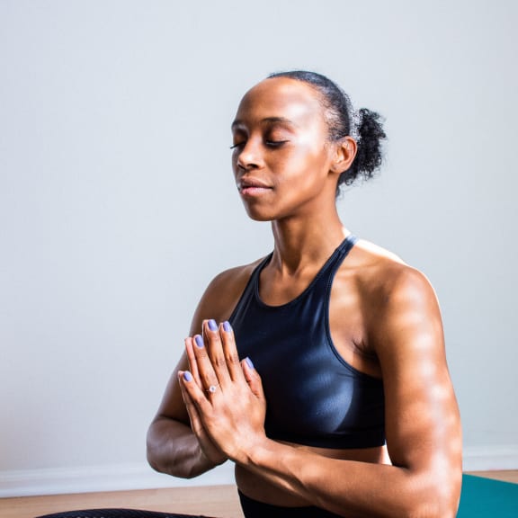a woman meditating on a yoga mat