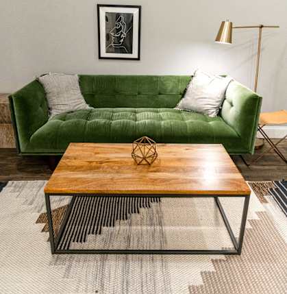 a living room with a green couch and a coffee table
