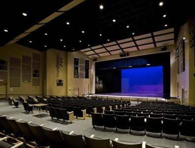 a large auditorium with rows of chairs in front of a stage