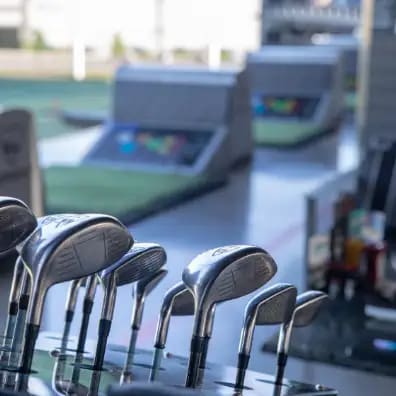 A set of golf clubs are lined up on a table.