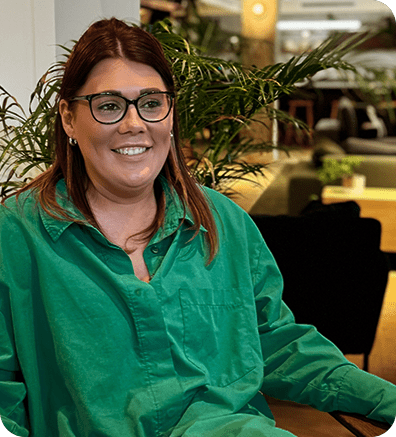 a woman wearing glasses and a green shirt sitting at a table
