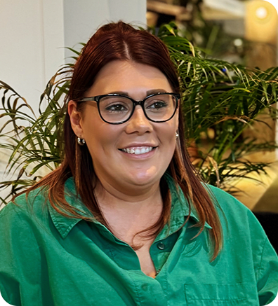 a woman wearing glasses and a green shirt sitting at a table